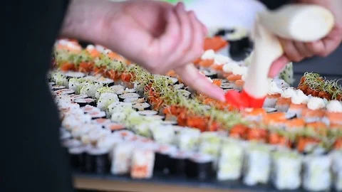 Hands arranging different sushi appetizers on a plate Stock Footage 72388041