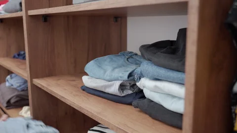 Hands arranging folded clothes in wooden wardrobe Stock Footage 337401988