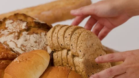 Hands Arranging Fresh Sliced Bread and Assorted Bakery Pastries Stock Footage 337691075