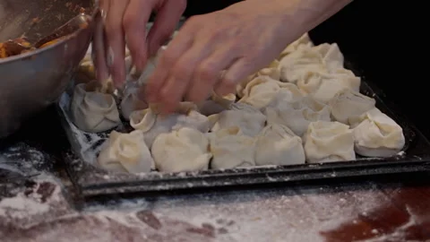 Hands Arranging Raw Manti on Tray in Ship Galley 動画素材 334885484