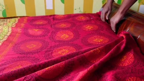 Hands Arranging Red Patterned Bedsheet on Bed Stock Footage 334697526