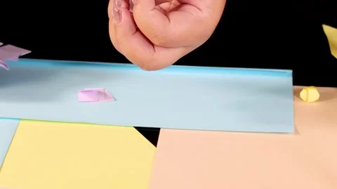 Hands Arranging Small Paper Crafts on Pastel Colored Background Vídeos de archivo 327426053