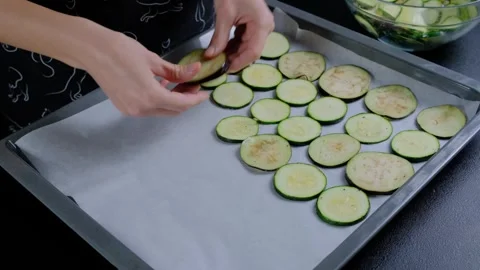 Hands Arranging Zucchini Slices on Baking Sheet Cooking Stock Footage 341446432