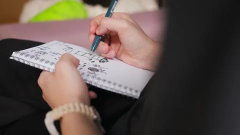 Hands of artist drawing with pen in notebook indoors, close-up shot Stock Footage 268730884