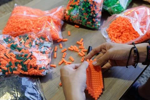 Hands Assembling Colorful Plastic Construction Blocks for Learning Stock Photos