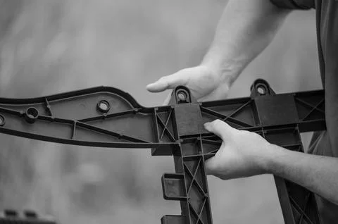 Hands assembling a complex plastic part. Precise work in progress. Manufacturing Foto stock