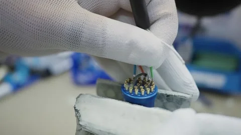 Hands assembling a connector with colorful wires in a cable production plant, Stock Footage 319503854