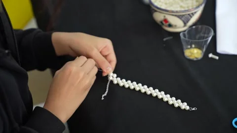 Hands Assembling Handmade Pearl Bracelet with Silver Extension Chain Vídeos de archivo 333562861