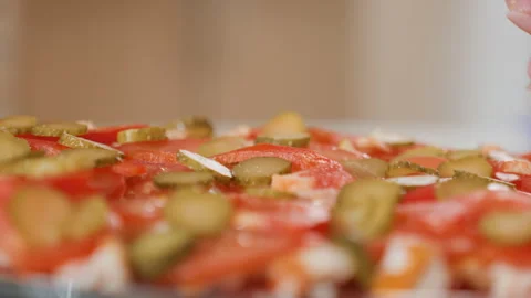 Hands assembling open-faced flatbread with sliced tomatoes, pickles, soft Stock Footage 343677797