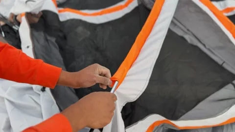 Hands Assembling Tent, Camping Gear Close-Up on Sand, Pole Through Fabric Sleeve Stock Footage 323915711