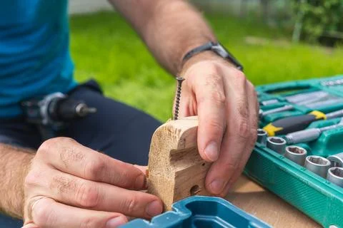 Hands assembling a wooden piece during DIY woodworking repair in backyard Stockfoto's
