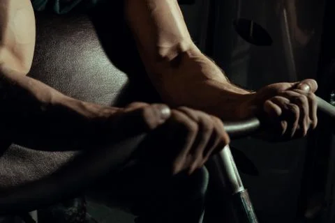 Hands of an athlete close-up, which does an exercise with a barbell. gym. biceps Stock Photos