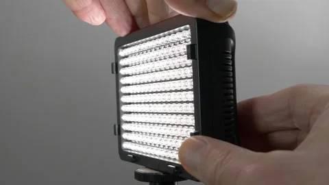 Hands attaching a battery then switching on a portable LED light. Stock Footage 150742601