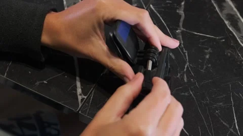 Hands attaching clip mount to action camera close-up on table, tightening Video stock 333478907