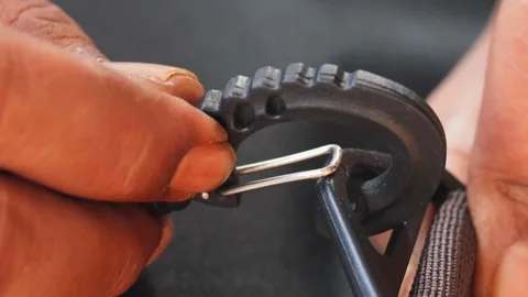 Hands attaching a plastic strap hook to a backpack strap Video stock 339044320