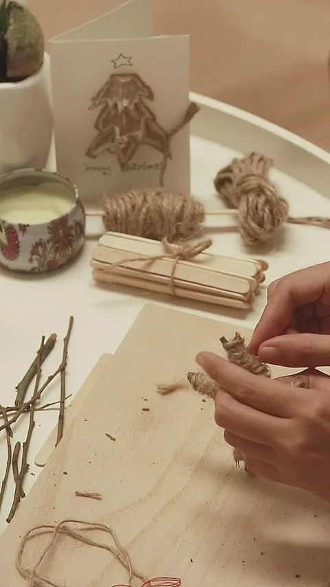 Hands attaching a red string to a handmade Christmas star ornament Video stock 294922903