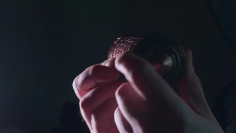 Hands attempt to solve metal cipher puzzle lock in dark room Stock Footage 330969951