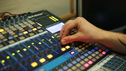 Hands of Audio engineer working on a professional analog console, mixing music Video stock 93509412