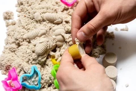 Hands on the background of kinetic sand. construction of turrets Foto stock