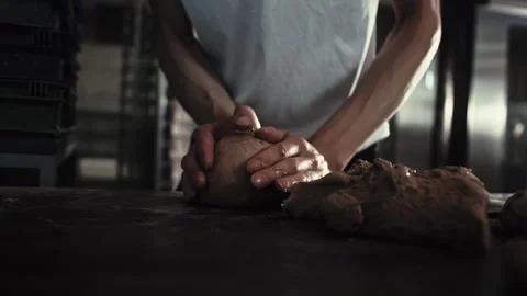 Hands of baker kneading dough on dark table surface. Craft of bread making Stock Footage 344093978