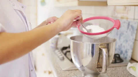 Hands of a baker putting caster sugar through a sieve Stock Footage 61581565