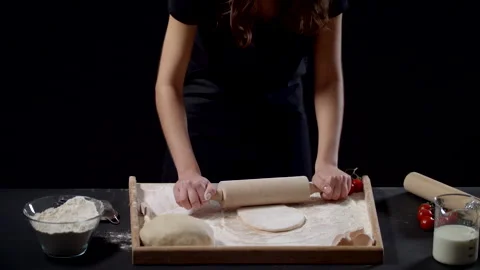 Hands Of Baker Rolls Dough In Flour On Wooden Board On Table With A Rolling Pin Stock Footage 170240708