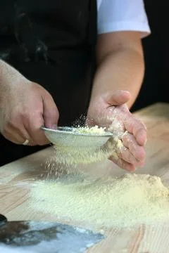 The hands of the baker sift Stock Photos