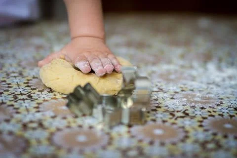 Hands baking dough with rolling pin on table. little chef  bake in kitchen. Stock Photos