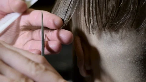 The hands of a barber with scissors making haircut in a barbershop. Slow motion Stock Footage 67856182