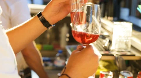 Hands bartender poured champagne into two glasses with cocktail red wine glasses Stock Footage 68626643