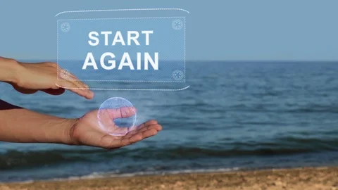 Hands on beach hold hologram text Start Again Stock Footage 107130510