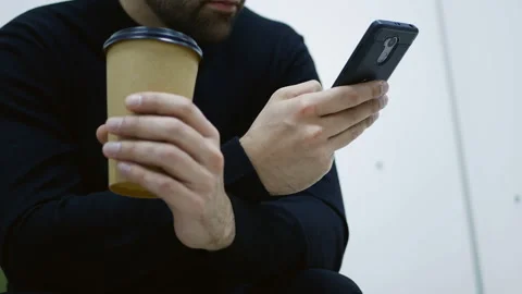 Hands of a bearded caucasian guy holding a paper cup with black coffee Stock Footage 124028627