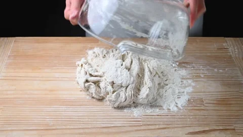 Hands begin to knead the pizza dough on pastry board. Stock Footage 146179736
