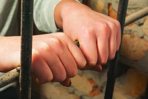Hands behind the bars Stock Photos
