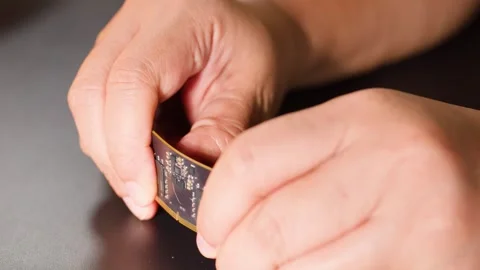 Hands Bending a Flexible Circuit Board with Microchips and Electronics Stock Footage 327107767