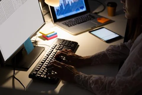 Hands of biracial female programmer sitting at desk, using computer with coding 库存照片