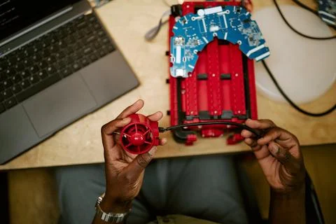 Hands of Black Engineer Assembling Robotic Device in Tech Lab Stock Photos