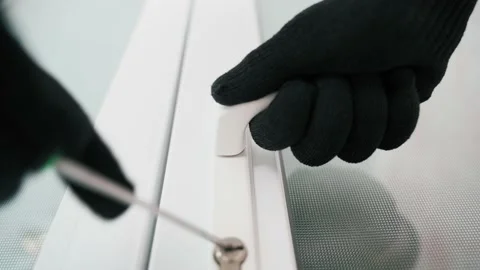 Hands in black gloves are trying to pick the lock in the white doors with a Stock Footage 227075362
