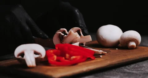 Hands in black gloves on black  background cut mushroom on black kitchen table. Stock Footage 148246218