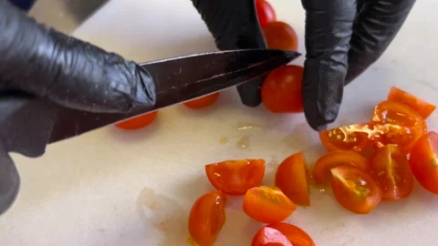 Hands with black gloves cutting cherry tomatoes Stock Footage 309548530