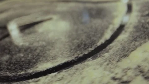 Hands in black gloves drawing a heart on a table sprinkled with flour. Stock Footage 300028368