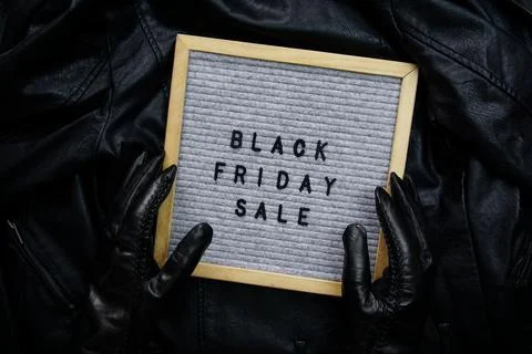 Hands in black gloves hold a frame with the inscription - Black Friday sale Stock Photos