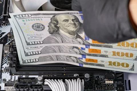 Hands in black gloves inserting 100-dollar bills into empty RAM slots on a .. Stock Photos
