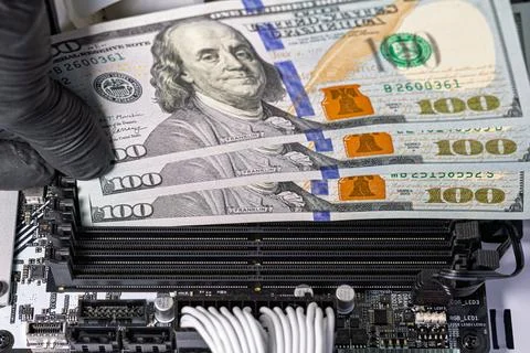 Hands in black gloves inserting 100-dollar bills into empty RAM slots on a .. 스톡 사진