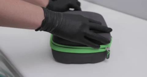 Hands in black gloves open a black case and pull out dental glasses Video stock 171824432