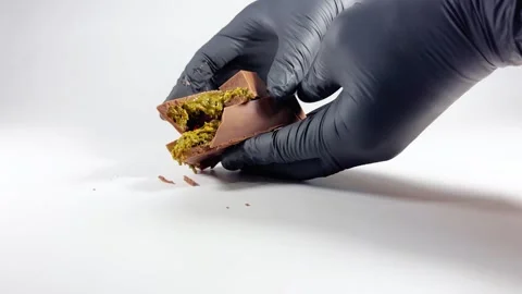 Hands in black gloves put pieces of Dubai chocolate on the table Stock Footage 309453789