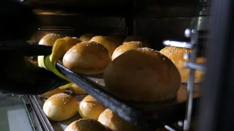 Hands in black gloves taking trays with round buns in a restaurant kitchen Stock-Footage 135218948