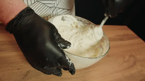 Hands in black latex gloves creating homogeneous dough mixture Video stock 330536581