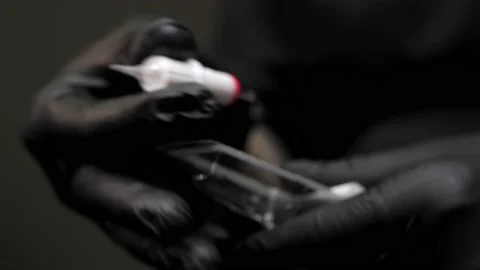 Hands in black latex gloves unpack the nozzle with a permanent makeup needle Stock Footage 200822150