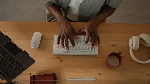 Hands of Black Man Typing on Wireless Keyboard Working at Office Desk Stock Footage 347654019